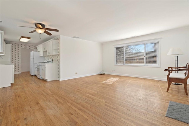 unfurnished living room featuring baseboards, ceiling fan, visible vents, and light wood finished floors