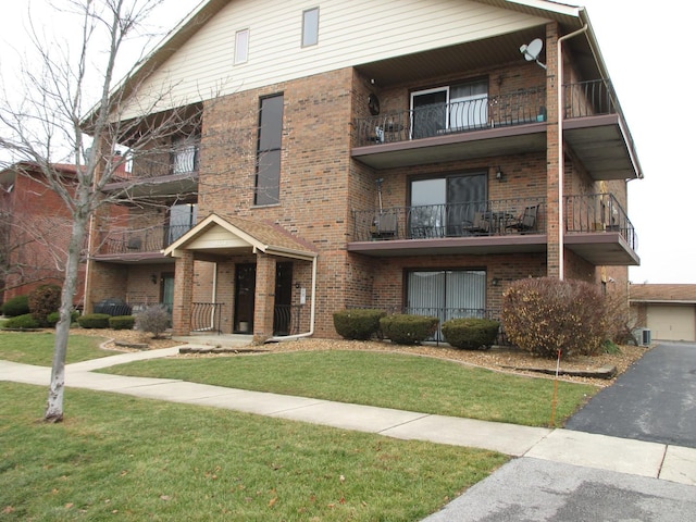 view of front facade with a front yard and brick siding