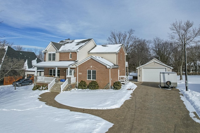 front of property featuring a porch, a garage, and an outbuilding