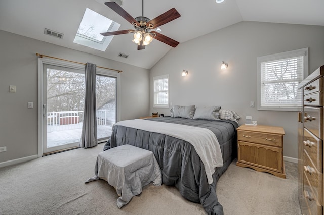 bedroom with ceiling fan, access to exterior, light colored carpet, and lofted ceiling with skylight