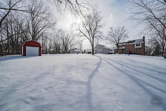 snowy yard featuring an outbuilding and a garage