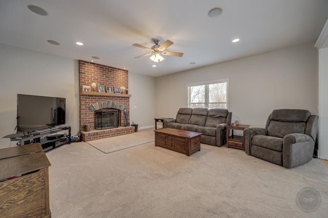 living room with ceiling fan, light colored carpet, and a fireplace