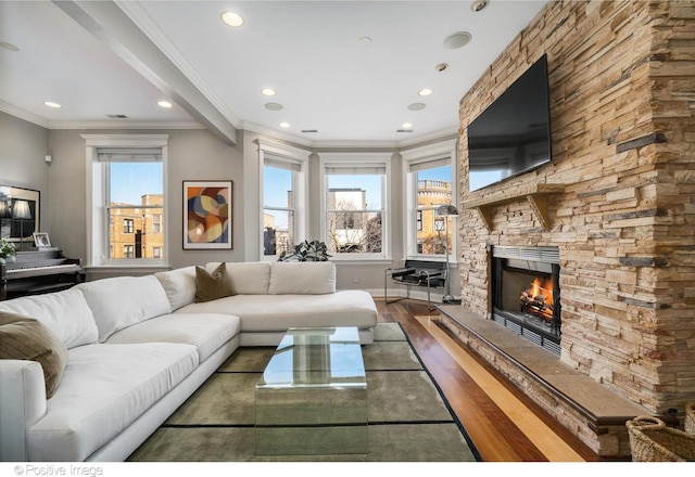 living area featuring a stone fireplace, baseboards, ornamental molding, recessed lighting, and dark wood-style flooring