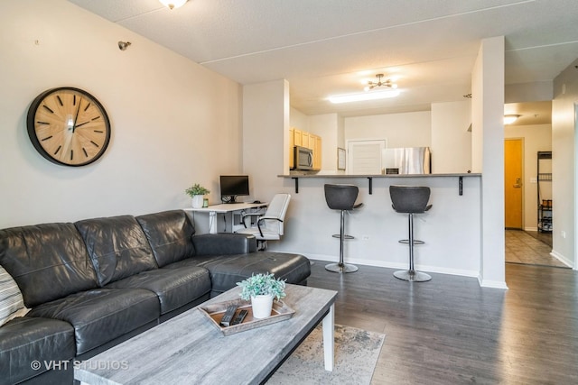 living area featuring dark wood-style flooring and baseboards