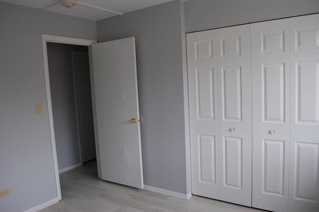 unfurnished bedroom featuring light hardwood / wood-style floors and a closet