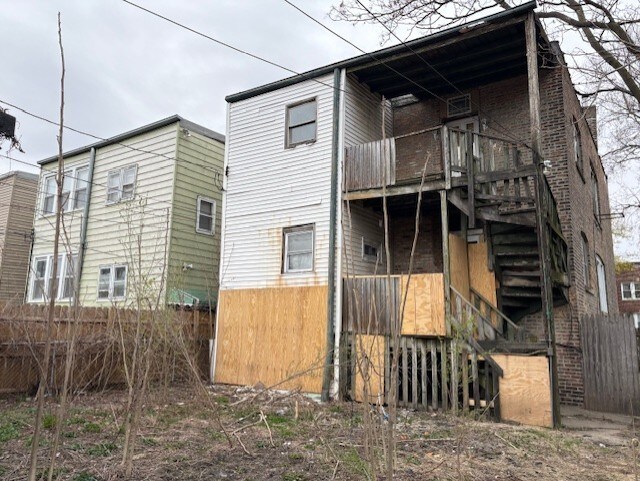 rear view of house with stairs, fence, and a wooden deck