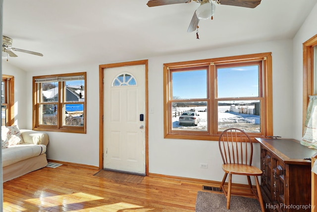 entryway featuring baseboards, a ceiling fan, visible vents, and light wood-style floors