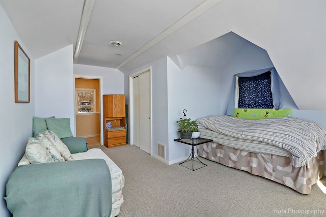 carpeted bedroom featuring lofted ceiling, a closet, visible vents, and baseboards