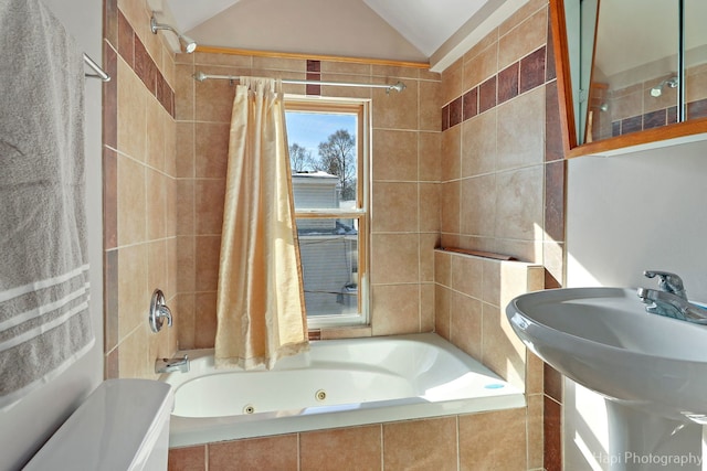 full bathroom featuring lofted ceiling, a sink, and a combined bath / shower with jetted tub