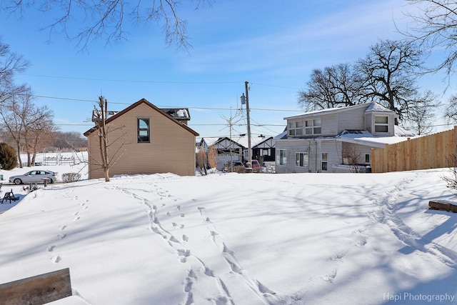 snowy yard featuring fence