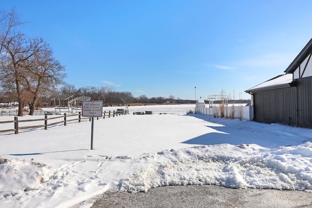 snowy yard featuring fence