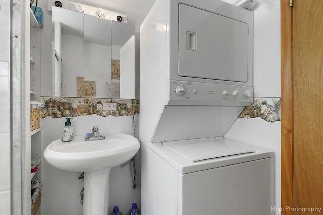 clothes washing area featuring laundry area and stacked washing maching and dryer