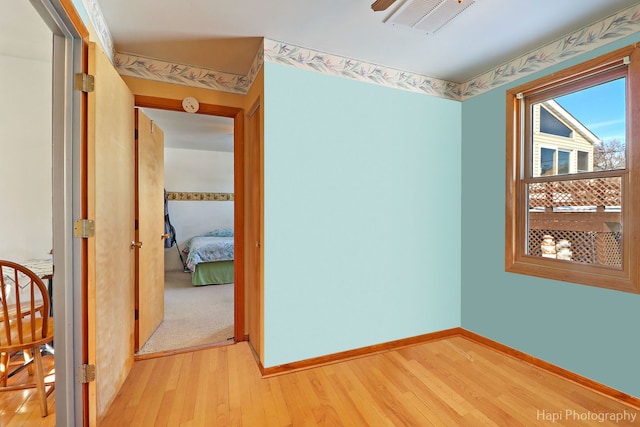 spare room featuring baseboards, visible vents, and light wood-style floors