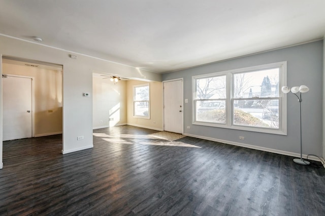 interior space featuring dark wood-style flooring, a ceiling fan, and baseboards