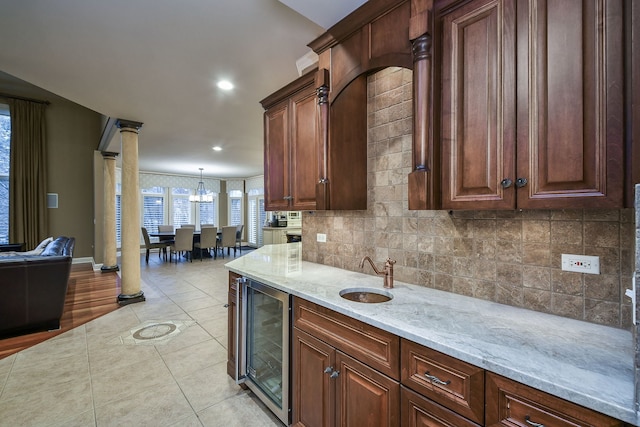 kitchen featuring light tile patterned floors, sink, beverage cooler, light stone counters, and tasteful backsplash