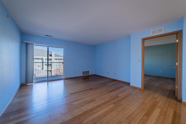 spare room featuring visible vents, light wood-style flooring, and baseboards