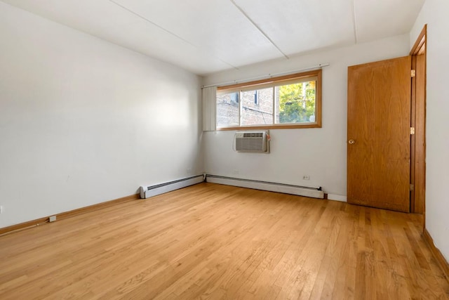 unfurnished room featuring an AC wall unit, a baseboard heating unit, and light hardwood / wood-style flooring