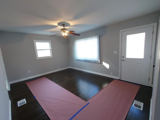 foyer entrance with baseboards, visible vents, and dark wood finished floors