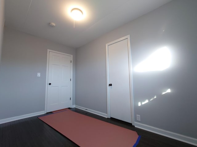 interior space with baseboards and dark wood-style flooring