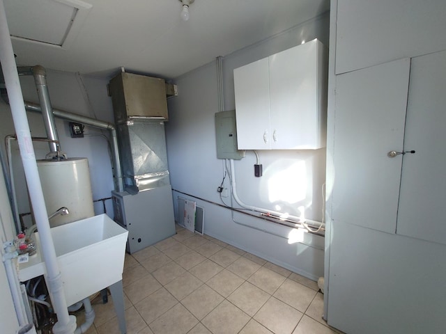 kitchen featuring light tile patterned floors, electric panel, white cabinets, water heater, and a sink