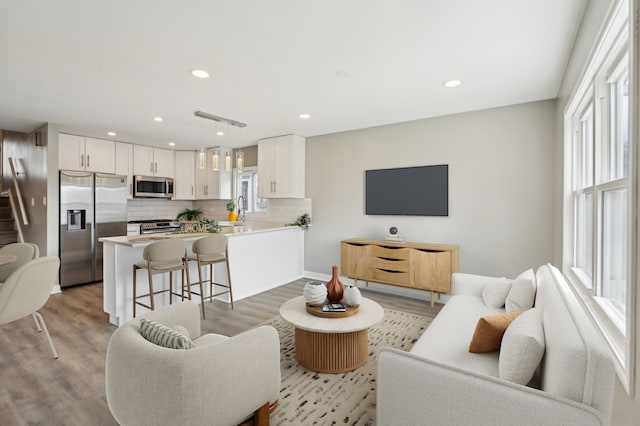 living room with light wood finished floors and recessed lighting