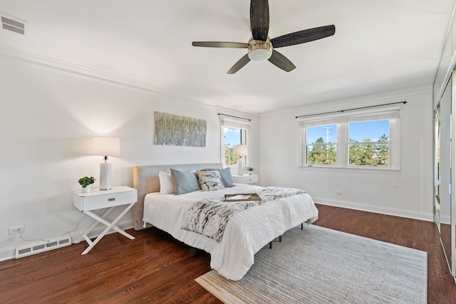 bedroom featuring visible vents, dark wood finished floors, and crown molding