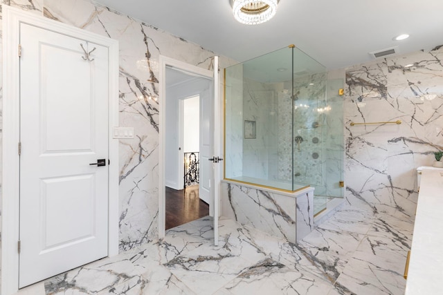 bathroom with a marble finish shower, marble finish floor, stone wall, and visible vents