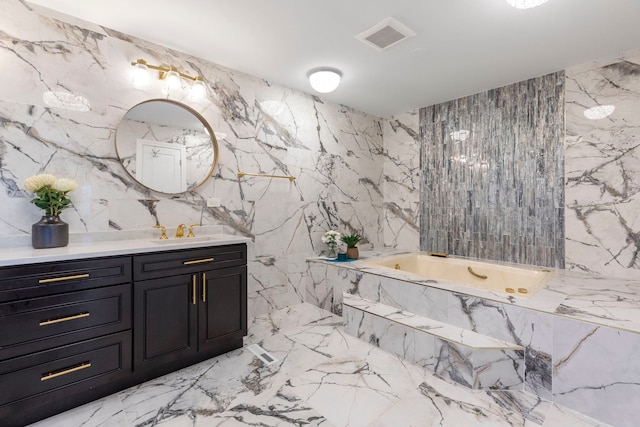 bathroom with visible vents, stone wall, vanity, and a garden tub