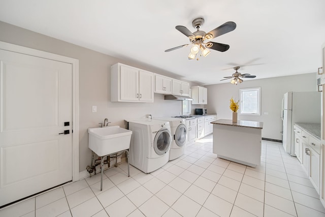 laundry area with light tile patterned floors, a ceiling fan, cabinet space, separate washer and dryer, and a sink