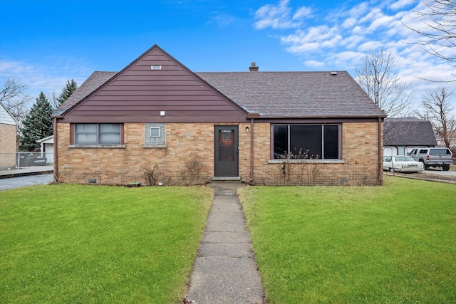 view of front of house featuring crawl space, brick siding, roof with shingles, and a front yard