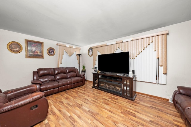 living area with baseboards and light wood finished floors