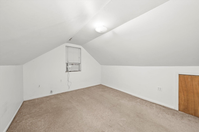 additional living space featuring carpet, lofted ceiling, and baseboards