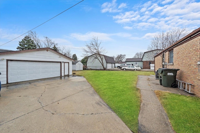 view of yard with a garage and an outbuilding