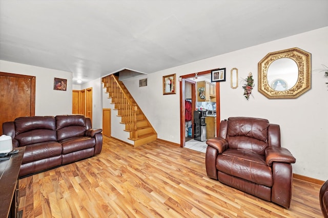 living area with baseboards, stairs, visible vents, and wood finished floors