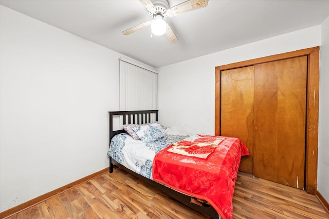 bedroom with light wood-type flooring, a closet, baseboards, and a ceiling fan