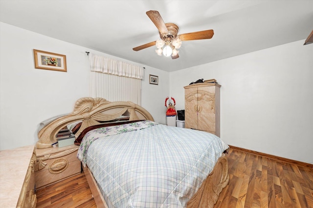 bedroom featuring a ceiling fan, baseboards, and wood finished floors