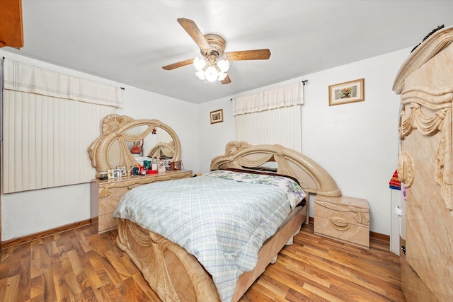 bedroom featuring wood finished floors, a ceiling fan, and baseboards