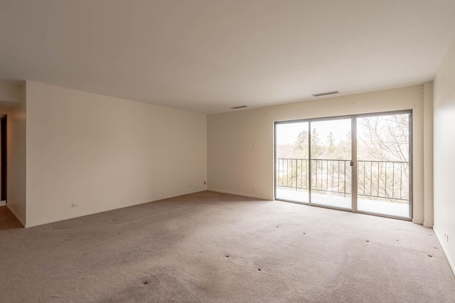 spare room with visible vents and light colored carpet