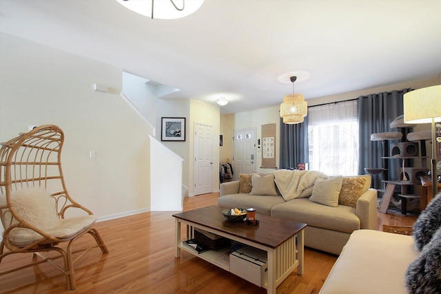 living area with light wood finished floors, stairway, and baseboards