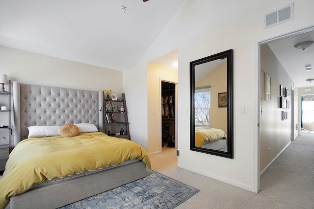 carpeted bedroom with visible vents, a walk in closet, baseboards, vaulted ceiling, and a closet