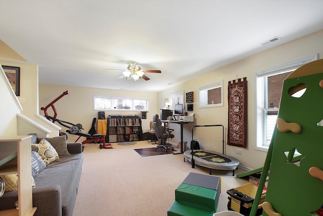 interior space featuring visible vents, ceiling fan, and carpet