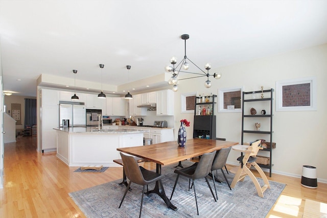 dining room featuring recessed lighting, baseboards, an inviting chandelier, and light wood-style flooring