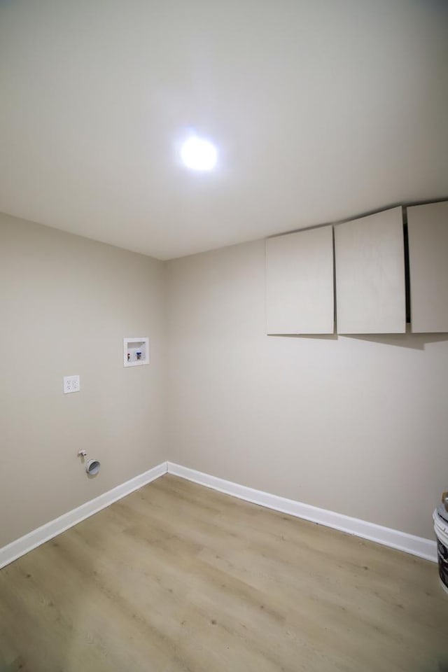 clothes washing area featuring laundry area, baseboards, washer hookup, and light wood finished floors