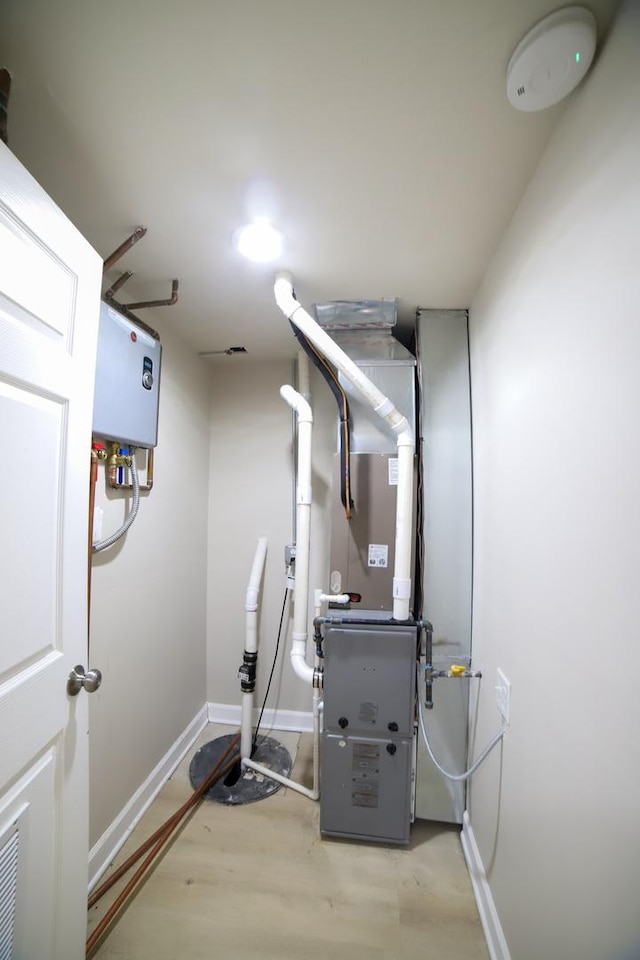 utility room featuring water heater and heating unit