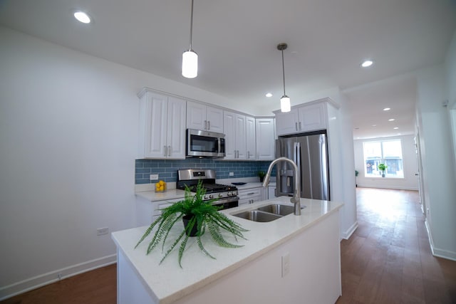 kitchen with hanging light fixtures, white cabinetry, stainless steel appliances, and a sink