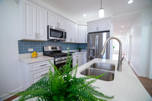 kitchen with white cabinetry, appliances with stainless steel finishes, tasteful backsplash, and a sink