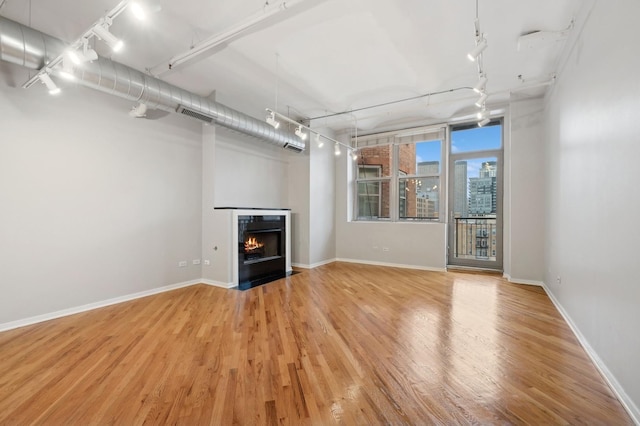 unfurnished living room featuring light hardwood / wood-style floors and track lighting