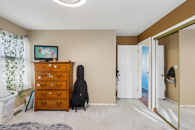 carpeted bedroom featuring a closet and baseboards