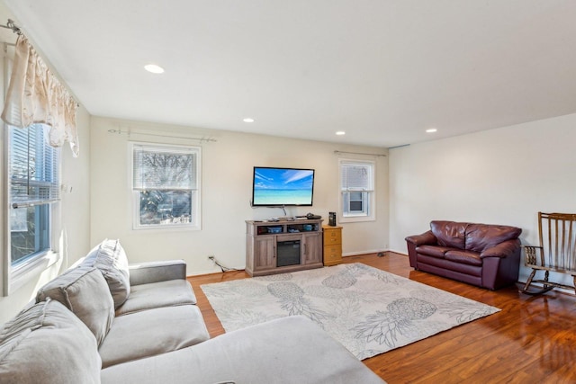 living area featuring baseboards, wood finished floors, and recessed lighting