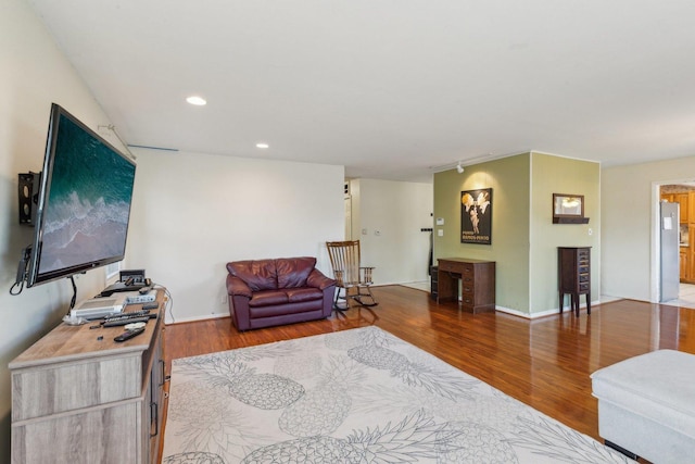 living area featuring recessed lighting, baseboards, and wood finished floors